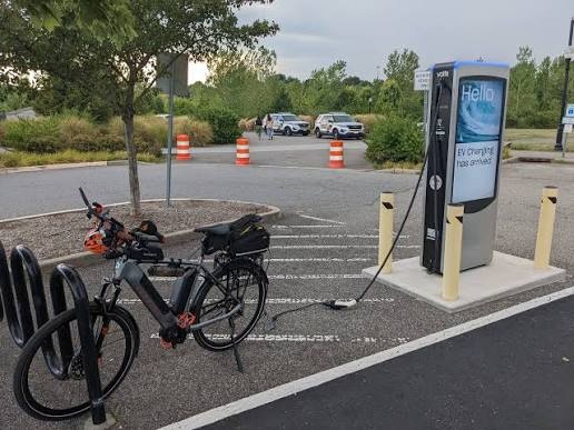 An electric bike charging at a public EV charging station, showcasing convenient charging solutions for modern e-bike riders.