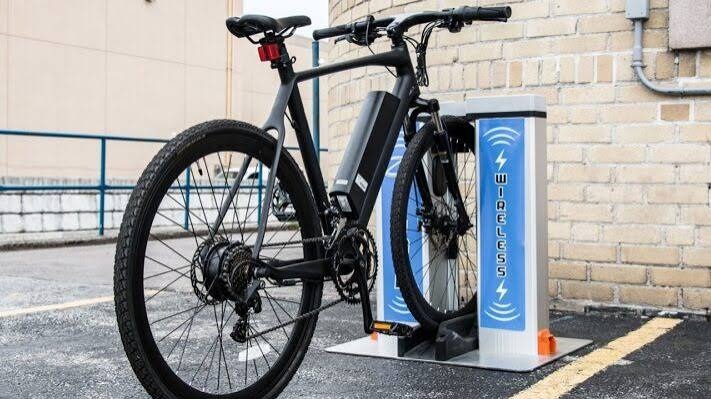 An advanced electric bike using a wireless charging station for convenient, cable-free battery charging and enhanced user convenience.