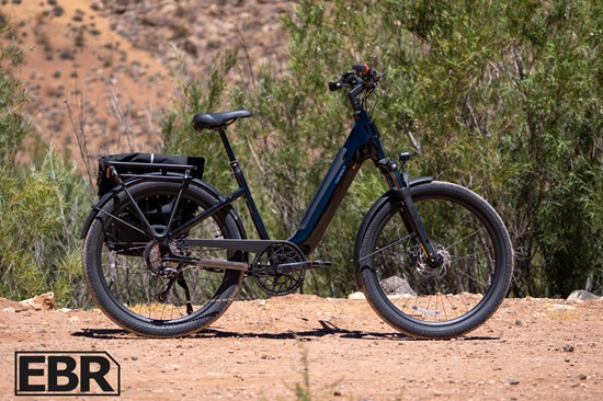 Black step-through electric bike with a rear-mounted battery pack, front suspension, and cargo rack designed for long-distance commuting and utility riding.