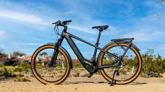 Ride1Up Prodigy V2 e-bike with a sleek step-through-inspired frame, integrated mid-drive motor, and rear cargo rack for versatile riding.
