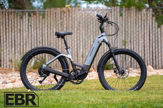 Modern gray commuter e-bike featuring an integrated battery, front suspension, and upright riding position for smooth everyday travel.